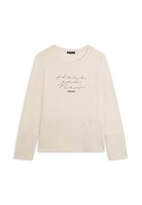 Top de manga larga color beige claro hecho de tela suave con un escote redondo. Presenta detalles texturizados en las mangas y letras impresas que dicen "Aquí y Ahora."