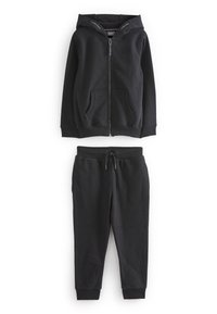 Schwarze Zip-Hoodie mit zwei Fronttaschen und gefütterter Kapuze, kombiniert mit passenden Jogginghosen mit elastischem Bund und Kordelzug.