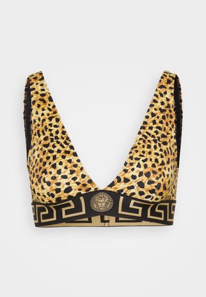 Bralette dengan pola macan tutul yang menampilkan leher V dalam, pinggang hitam dengan pola kunci Yunani berwarna emas, dan lambang emas pusat dengan desain kepala.