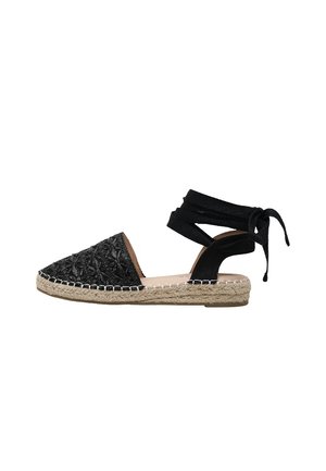 Sandalia espadrille negra con suela de yute trenzado, punta cerrada y lazos para atar alrededor del tobillo, mostrada de perfil sobre fondo blanco.