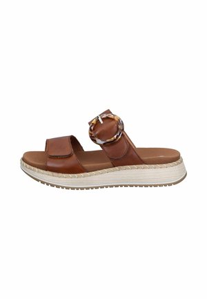 Brown leather slide sandal with two straps, a large tortoiseshell buckle, padded footbed, and white textured platform sole.