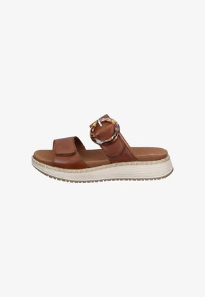 Brown leather slide sandal with two straps, a large tortoiseshell buckle, padded footbed, and white textured platform sole.