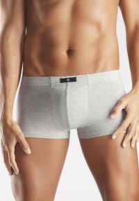 Graue Baumwoll-Boxershorts mit enger Passform, ausgestattet mit einem schwarzen Bund und einer einzigen Vordernaht. Glatte Textur, keine sichtbaren Muster oder Akzente.