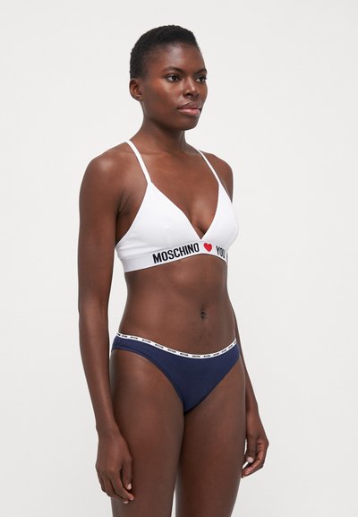 White bikini top with thin straps and black/red branding reading "MOSCHINO ♥ YOU," paired with navy blue bikini bottoms featuring white branding.