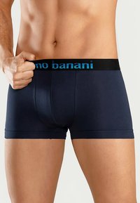 Marineblauwe katoenen boxershorts, strak model, met een zwarte tailleband met het "no banani"-logo in lichtblauw. Gladde textuur, tot halverwege de dij.