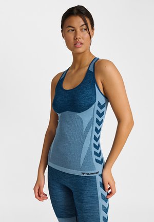 Niebieski sportowy top na ramiączkach o teksturowanym wykończeniu. Zawiera kontrastujące jaśniejsze panele i zygzakowate akcenty wzdłuż boków. Logo na dole.