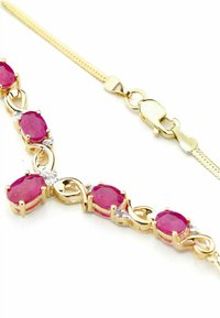 Zlatý náramok s oválnymi ružovými drahokamami, medzi ktorými sú umiestnené jasné akcenty, hladké články a sponou na homára. Textúrovaná časť reťaze.
