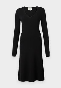 Black ribbed knit dress with long sleeves and a deep V-neck. A-line shape with a flared hem, made from a soft, textured fabric.