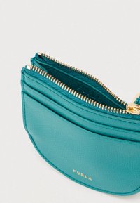 Sinine-roheline nahast rahakott kuldse tõmblukuga ja esiküljel reljeefne kaubamärk "Furla". Varustatud mitme kaarditaskuga ja siledapinnaline tekstuur.