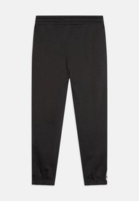 Schwarze Sporthose aus dehnbarem Stoff, mit einem elastischen Bund und umgeschlagenen Säumen. Ein kleines Logo ist an der Seite sichtbar.
