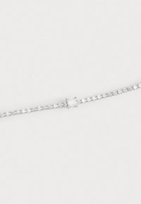 Bracciale d'argento con una fila di piccoli gemme trasparenti e una pietra quadrata grande al centro, tutto montato su una delicata catena.