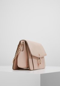 Borsa a tracolla in pelle rosa chiaro con patta piegata, tracolla in catena dorata e dettagli hardware audaci. Finitura texture con accenti lisci.