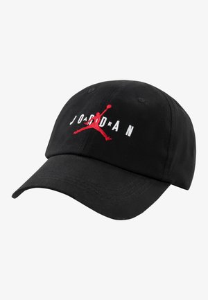Črna bombažna bejzbol kapa z ukrivljenim vizirjem, izvezenim belim napisom "JORDAN" in rdečim Jumpman logotipom spredaj.