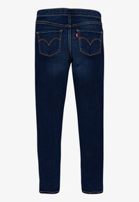 Jeans in denim blu scuro con una vestibilità dritta. Presentano due tasche posteriori con un motivo di cucitura e una targhetta rossa sulla tasca sinistra.