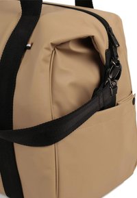 Borsa rettangolare beige con tracolla nera regolabile, chiusura con zip e una tasca esterna sul lato.