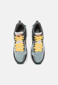 Athletic shoes featuring a breathable mesh upper in shades of grey and teal, with bright yellow laces and a white sole. Notable logo branding visible.