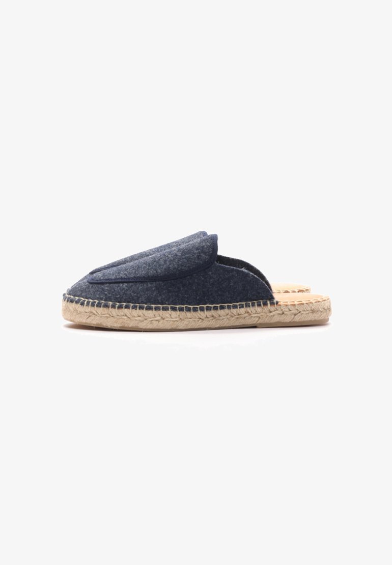 Zapatilla de casa azul marino de fieltro, tipo slip-on, con punta redondeada, solapa delantera elevada y suela de yute trenzado. Diseño minimalista con acentos contrastantes.