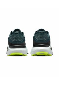 Zapatillas de running Nike con parte superior de textil verde oscuro, acentos negros y detalles reflectantes. Cuenta con una entresuela blanca y una suela exterior amarilla brillante.