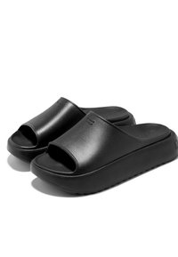 Zapatillas de plataforma negras hechas de material sintético suave, con un diseño de punta abierta y una ligera textura en la suela para mayor agarre.