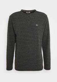 Dunkelgraues Langarm-Henley-Shirt mit Rundhalsausschnitt, Drei-Knopf-Leiste und kleinem Logo auf der Brust. Weiches, strukturiertes Material.