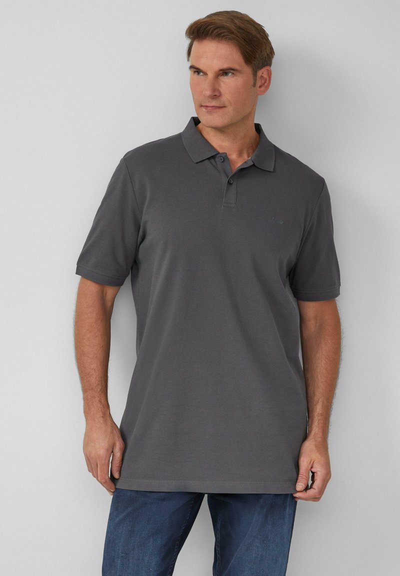 Szara koszulka polo z ribbowym wykończeniem, krótki rękaw i klasyczny kołnierzyk, zestawiona z niebieskimi dżinsami. Prosty design, bez widocznych wzorów.