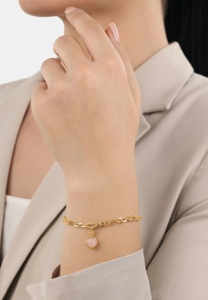 Bracciale in oro con pendente a forma di gemma rosa rotonda. La catena presenta maglie di diverse dimensioni, con una superficie liscia e una finitura lucida.