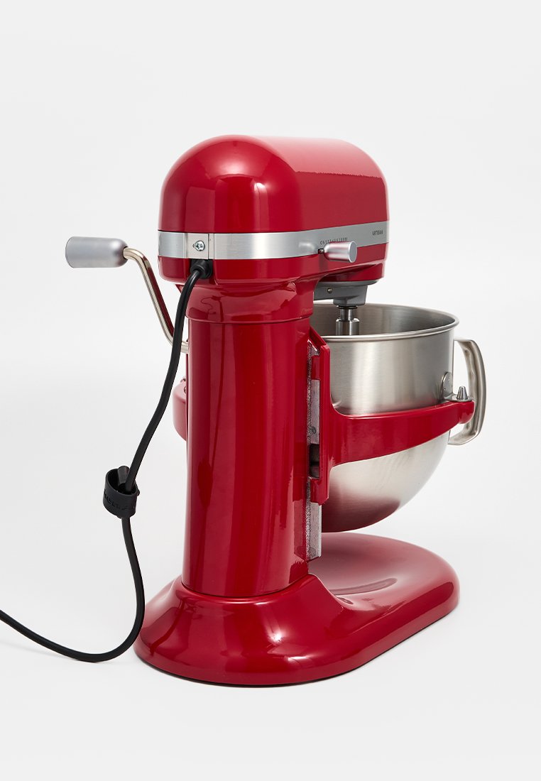 Rode voedselmixer met een glanzende afwerking, roestvrijstalen kom en ergonomische handgreep. Voorzien van een controleknop en stroomkabel aan de zijkant.