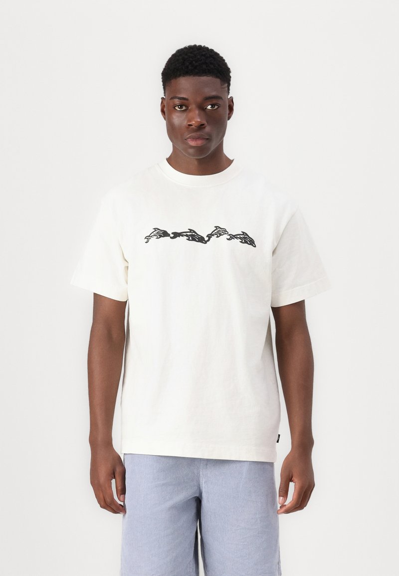 Weißes Baumwoll-T-Shirt mit einem schwarzen grafischen Design von laufenden Kaninchen auf der Brust. Kurze Ärmel und ein runder Ausschnitt.