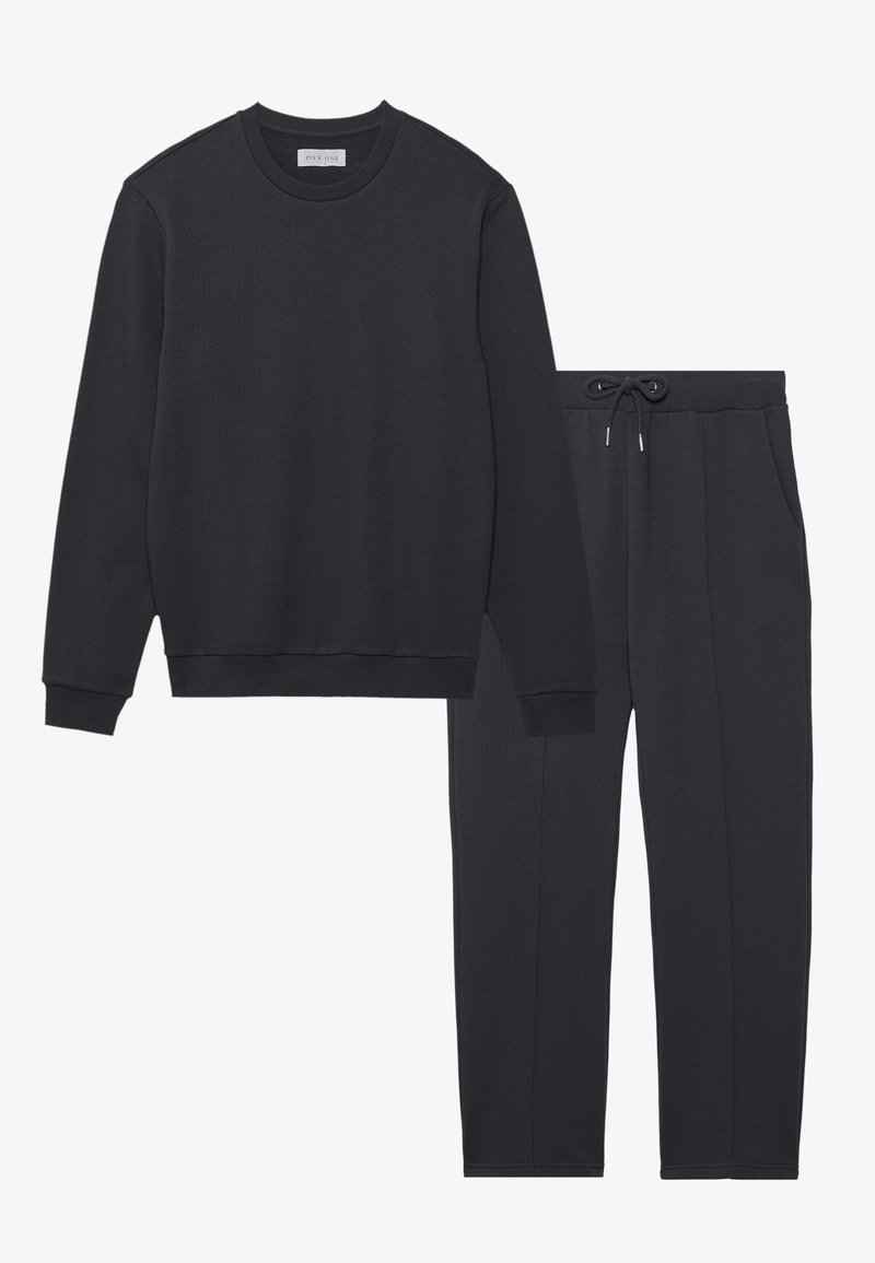 Conjunto de sudadera gris oscuro y pantalones a juego. La sudadera tiene una textura acanalada y cuello redondo; los pantalones tienen una cintura elástica con cordón.