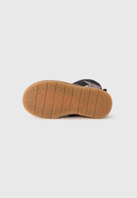 Zwarte schoenen met een gestructureerde rubberen zool, voorzien van een veelkleurig gespikkeld ontwerp op het teengebied. De zool heeft horizontale groeven voor grip.