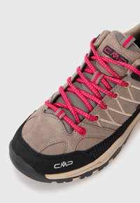 Scarpa da trekking grigia con lacci rosa, materiale scamosciato testurizzato e punta in gomma nera. Presenta pannelli in rete e il logo CMP sul lato.