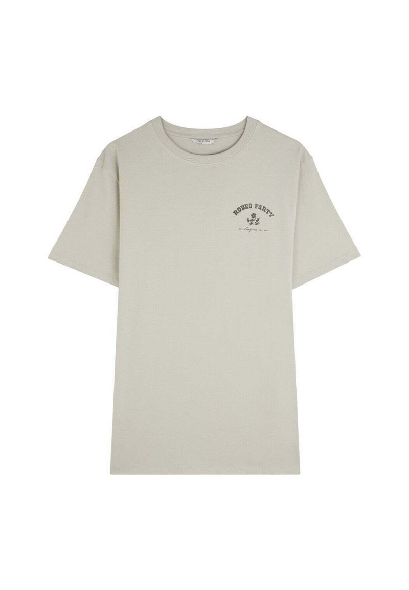 Camiseta de algodón color beige claro con mangas cortas y un cuello redondo. Presenta un pequeño texto gráfico negro en la parte superior izquierda del pecho.