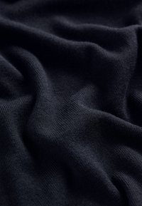 Donker marineblauwe brei stof met een gladde textuur, met subtiele golven en plooien. Het materiaal lijkt zacht en lichtgewicht.