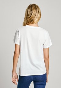 Vitt kortärmat T-shirt i bomull med rund halsringning och avslappnad passform, visad bakifrån. Slät textur, inga mönster.