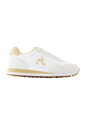 Sneaker bassa bianca e beige con chiusura con lacci, suola in gomma e logo con un uccello stilizzato sul lato.