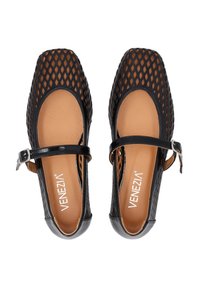 Schwarze Mary Jane Schuhe mit perforiertem Obermaterial, quadrater Zehenform und Knöchelriemen mit silberner Schnalle. Glatte beigefarbene Innensohle und strukturierte schwarze Seiten.