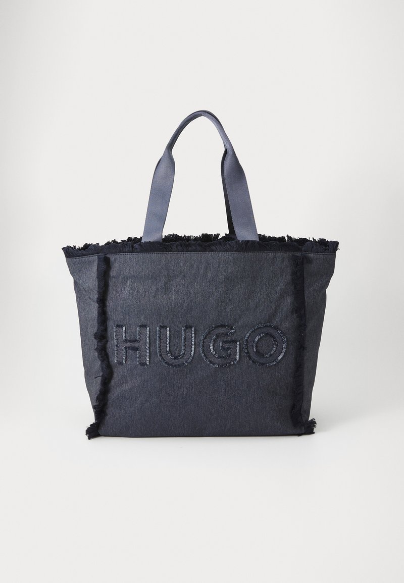 Ciemnoniebieska torba na ramię z postrzępionymi krawędziami i wytłoczonym logo "HUGO". Posiada mocne uchwyty z materiału do wygodnego noszenia.