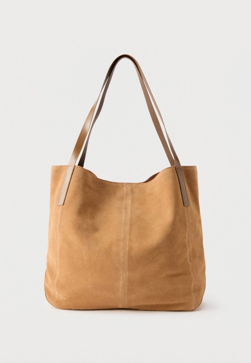 Sac cabas en daim couleur fauve avec doubles bretelles en cuir, design simple et coutures visibles sur fond blanc uni.