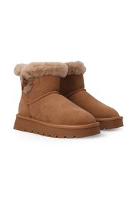 Hnědé semišové kotníkové boty s huňatým kožíškem a silnými gumovými podrážkami, zobrazené vedle sebe na bílém pozadí.