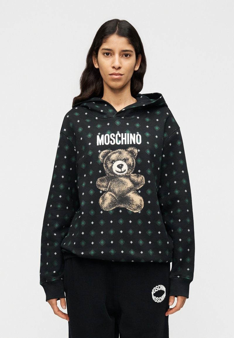 Μαύρο φούτερ με κουκούλα και γραφικό αρκούδας, με κείμενο "MOSCHINO". Διαθέτει μοτίβο με πράσινα διαμαντένια σχήματα. Απαλή υφή υφάσματος και ρυθμιζόμενη κουκούλα.