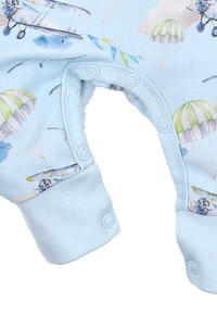 Jasnoniebieski kombinezon z nadrukiem samolotów i spadochronów, z zapięciami na zatrzaski na dole oraz teksturowanymi mankietami na nadgarstkach. Wykonany z miękkiej bawełny.