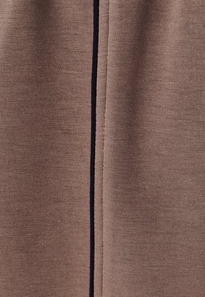 Bruine stof met een gladde textuur heeft een verticale zwarte streep. Het materiaal lijkt zacht en gebreid, geschikt voor casual kleding.
