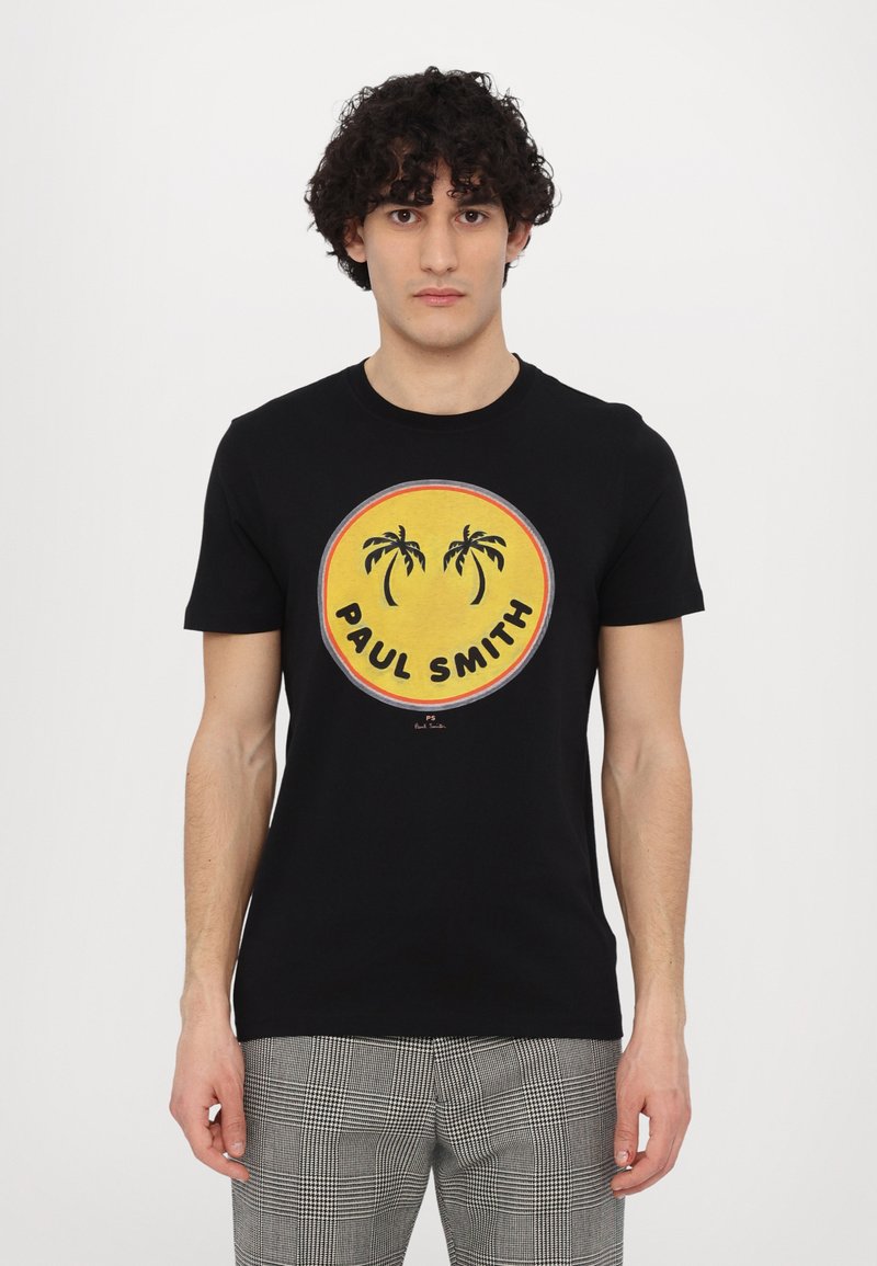 T-shirt noir à manches courtes avec un graphique circulaire jaune représentant des palmiers et le texte "PAUL SMITH", fabriqué en tissu coton.