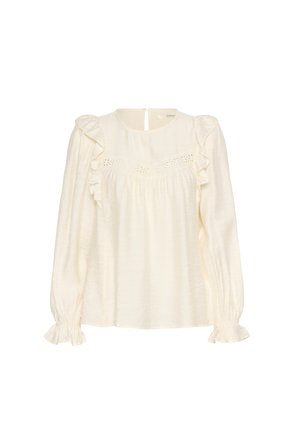 Cream-colored blouse with long sleeves, ruffled accents, and a textured finish. Features a keyhole back and embroidered detailing across the chest.