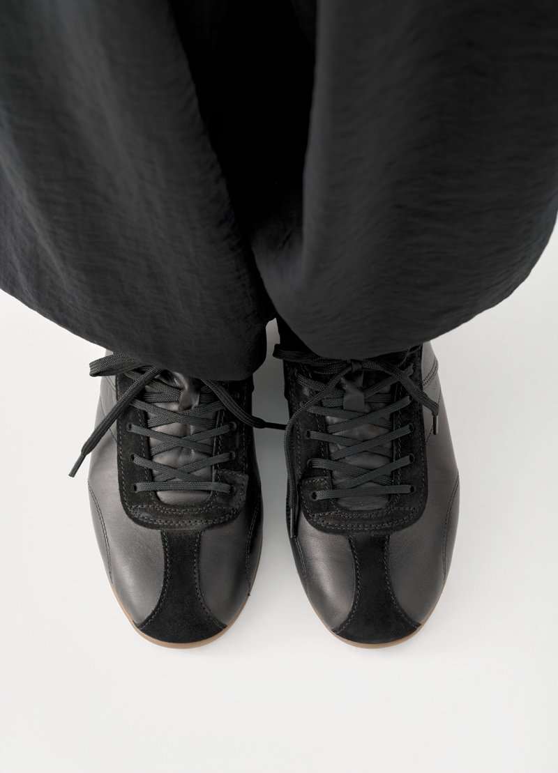 Μαύρα αθλητικά παπούτσια από δέρμα και σουέντ, με λείο φινίρισμα, σχεδιασμό με κορδόνια και αντίθετες υφές στη μύτη και στις πλευρές.