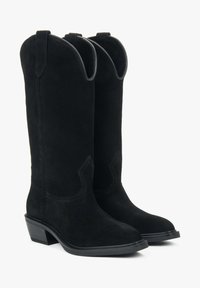 Czarne zamszowe kowbojki z wydłużonym noskiem, średniej wysokości obcasem blokowym i usztywnionymi cholewkami. Posiadają dekoracyjne przeszycia i pętle do zakładania.