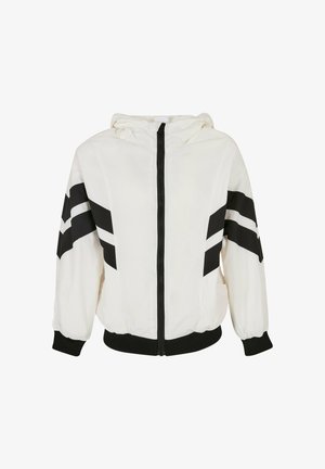 Weiße Kapuzenjacke mit schwarzen Streifen an den Ärmeln, ausgestattet mit einem Frontreißverschluss und elastischen Bündchen. Hergestellt aus leichtem Material.