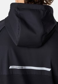 Schwarze Kapuzenjacke mit glatter Textur, weißem 'SWEDEMOUNT'-Logo und einem eleganten, minimalistischen Design.