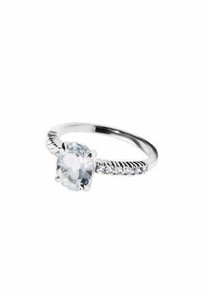 Anillo de plata con una gran piedra preciosa redonda y transparente en el centro, y piedras claras más pequeñas incrustadas a lo largo de los lados de la banda.