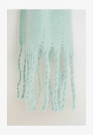 Minta zelena marama napravljena od mekog, dlačastog materijala s dugim, reseastim krajevima. Tekstura je lagana i prozračna, čime se pojačava njen delikatni izgled.